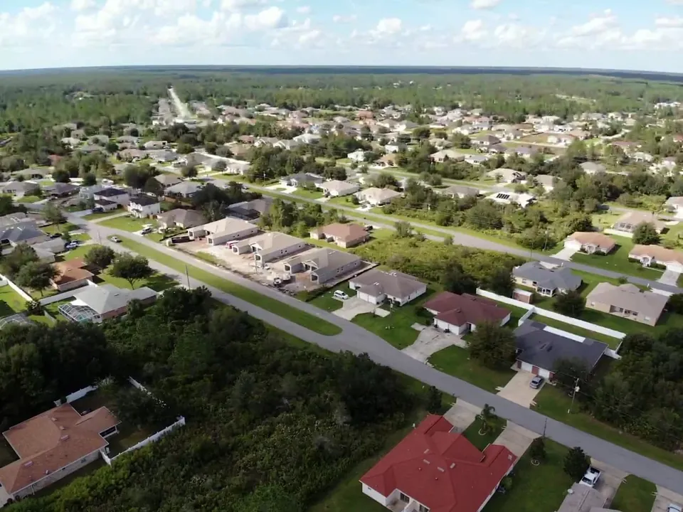 Aerial view of homes with varied roof shapes and surrounding trees